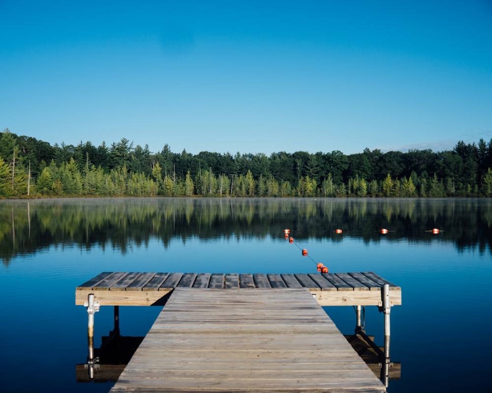 Houten steiger met boeien op stil water